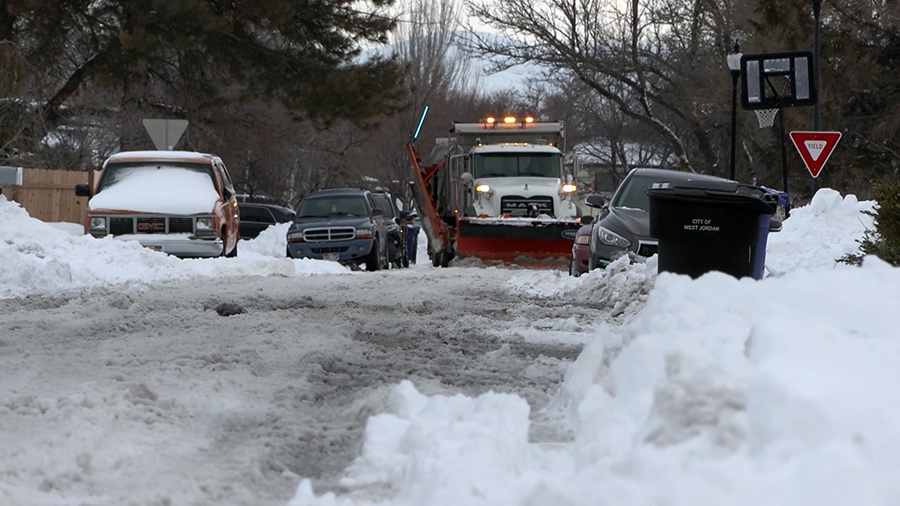 Plows have a tough time maneuvering between cars after a snowstorm in February in West Jordan. Some cities give warnings, others citations for parking violations.