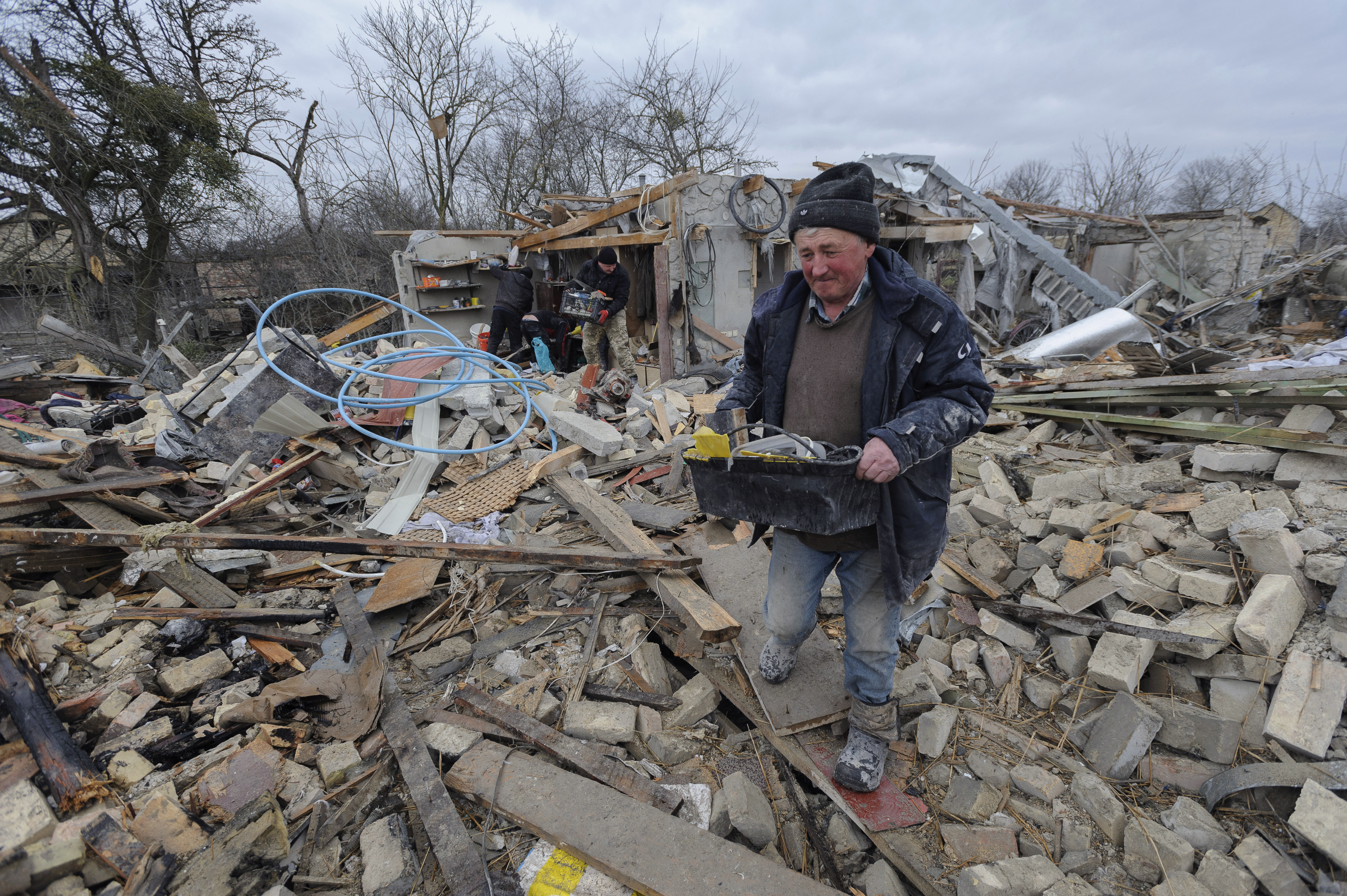 Villagers clear the rubble after Russia's night rocket attack ruined private houses in a village, in Zolochevsky district in the Lviv region, Ukraine, Thursday.