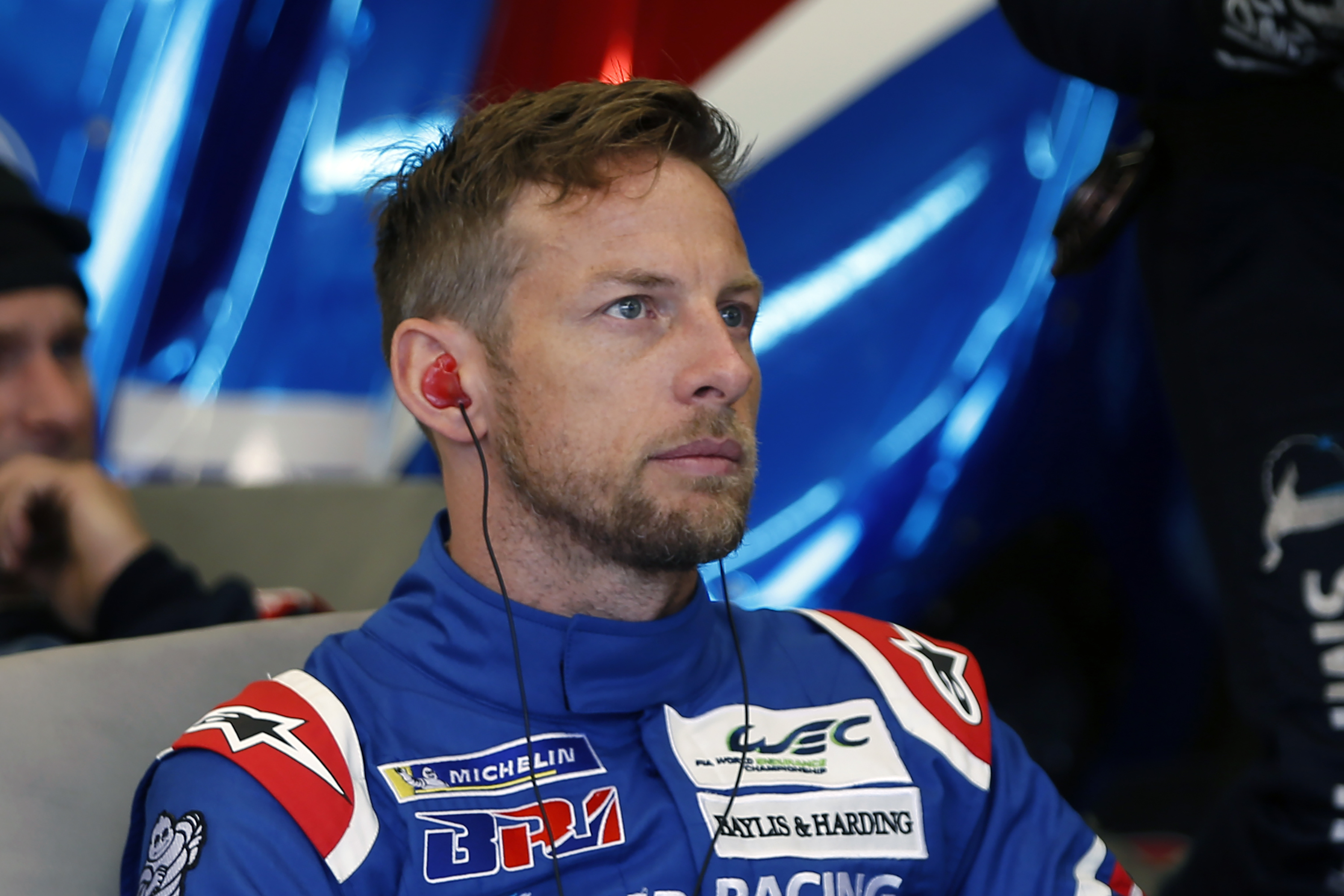 FILE - Britain's driver Jenson Button waits in stand during the 86th 24-hour Le Mans endurance race, in Le Mans, western France, Saturday, June 16, 2018. Button will make his NASCAR debut at Circuit of the Americas later this month in a car funded by longtime sponsor Mobil 1 and prepared by Stewart-Haas Racing. Button joins Kimi Raikkonen in the race – marking two former Formula One world champions in the lineup on the permanent road course in Austin, Texas. 