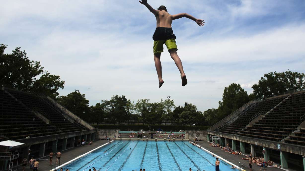 A boy jumps into the water at the Olympic open air public pool in Berlin, Germany, May 21, 2014. Women in Berlin will soon be allowed to go topless at the city's public pools, the Berlin state government said Thursday. The new bathing rules to allow both men and women to go swimming without covering their upper bodies came in reaction to a woman's complaint alleging discrimination because she was not allowed to swim topless in a swimming pool in Berlin, like men.