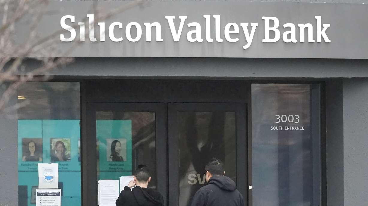 People look at signs posted outside Silicon Valley Bank in Santa Clara, Calif., Friday. The Federal Deposit Insurance Corporation is seizing the bank's assets.
