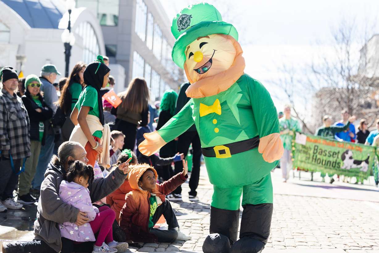 A leprechaun high fives parade watchers during the St. Patrick’s Day Parade at The Gateway in Salt Lake City on Saturday.