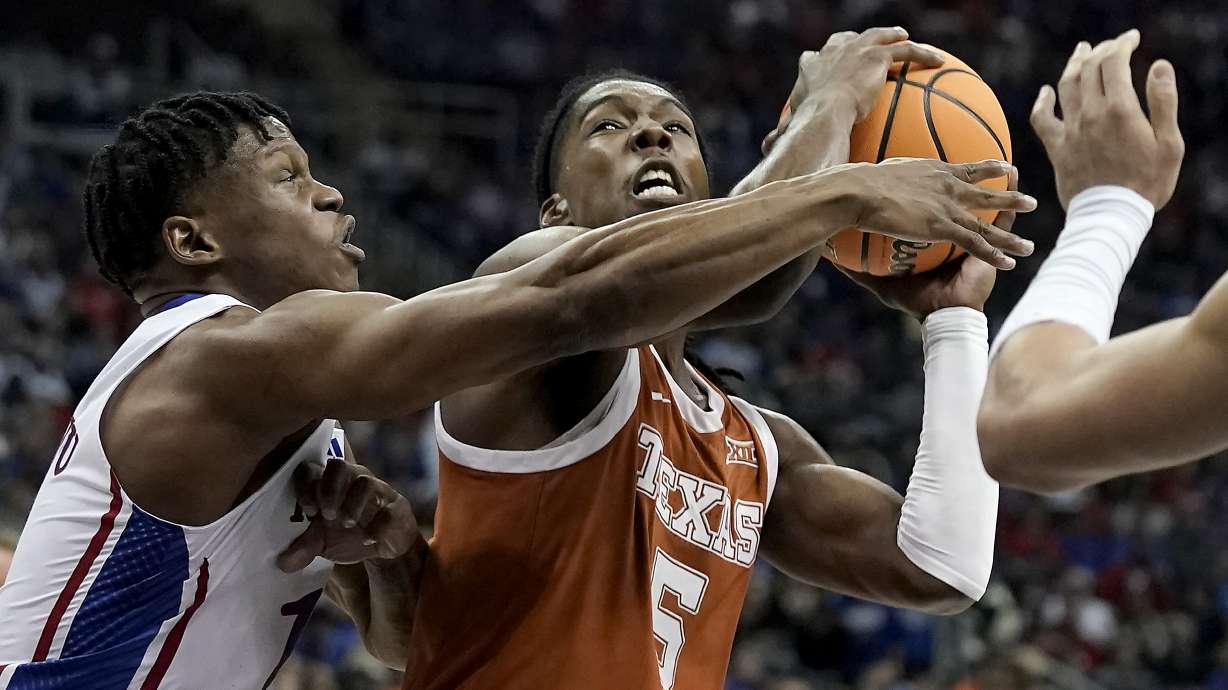 Texas guard Marcus Carr (5) shoots under pressure from Kansas guard Joseph Yesufu (1) during the first half of the NCAA college basketball championship game of the Big 12 Conference tournament Saturday, March 11, 2023, in Kansas City, Mo.