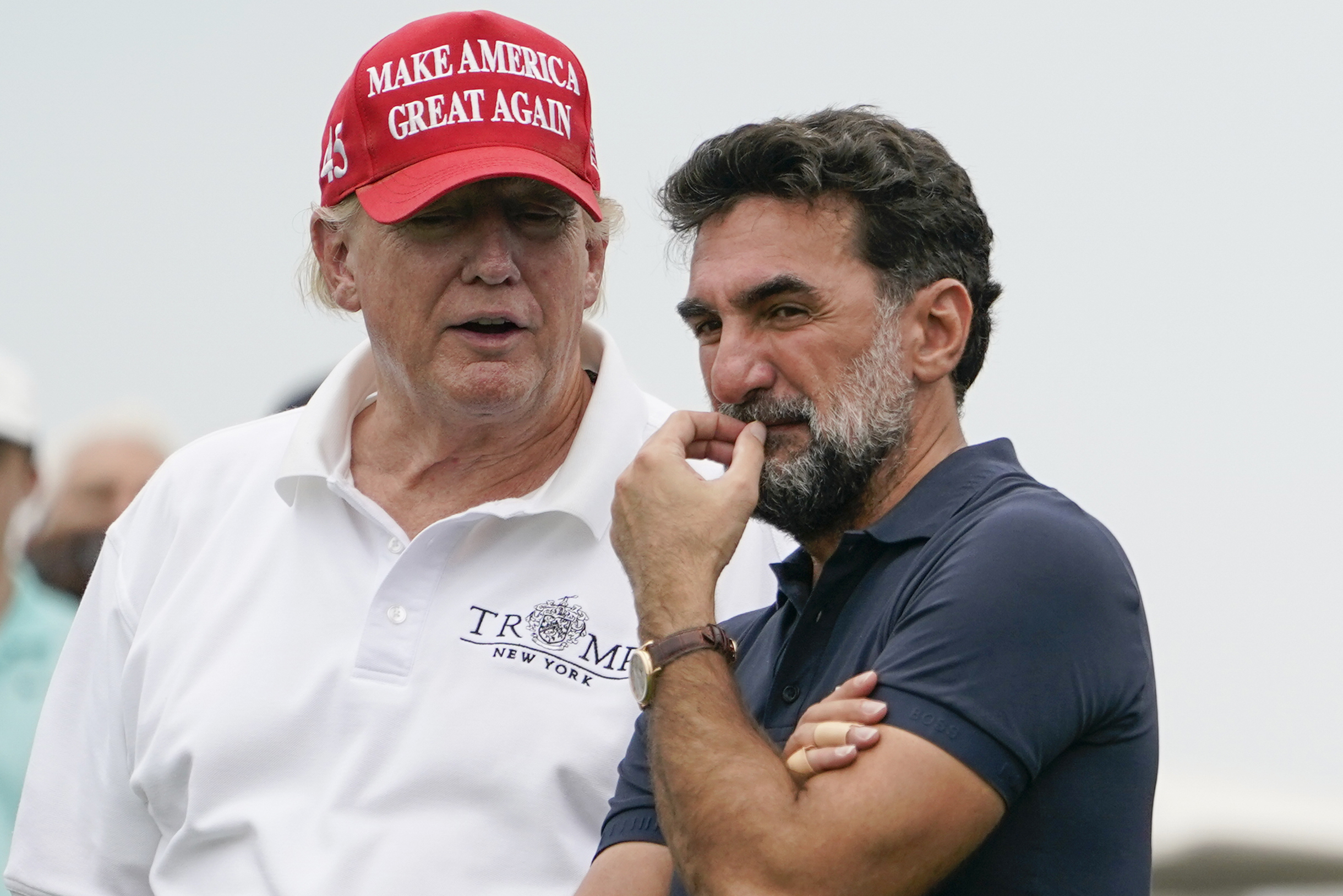 FILE - Former President Donald Trump, left, talks with Yasir Al-Rumayyan, governor of Saudi Arabia's Public Investment Fund, center, and Majed Al-Sorour, CEO of Golf Saudi, on the 16th hole during the first round of the Bedminster Invitational LIV Golf tournament in Bedminster, NJ., July 29, 2022.