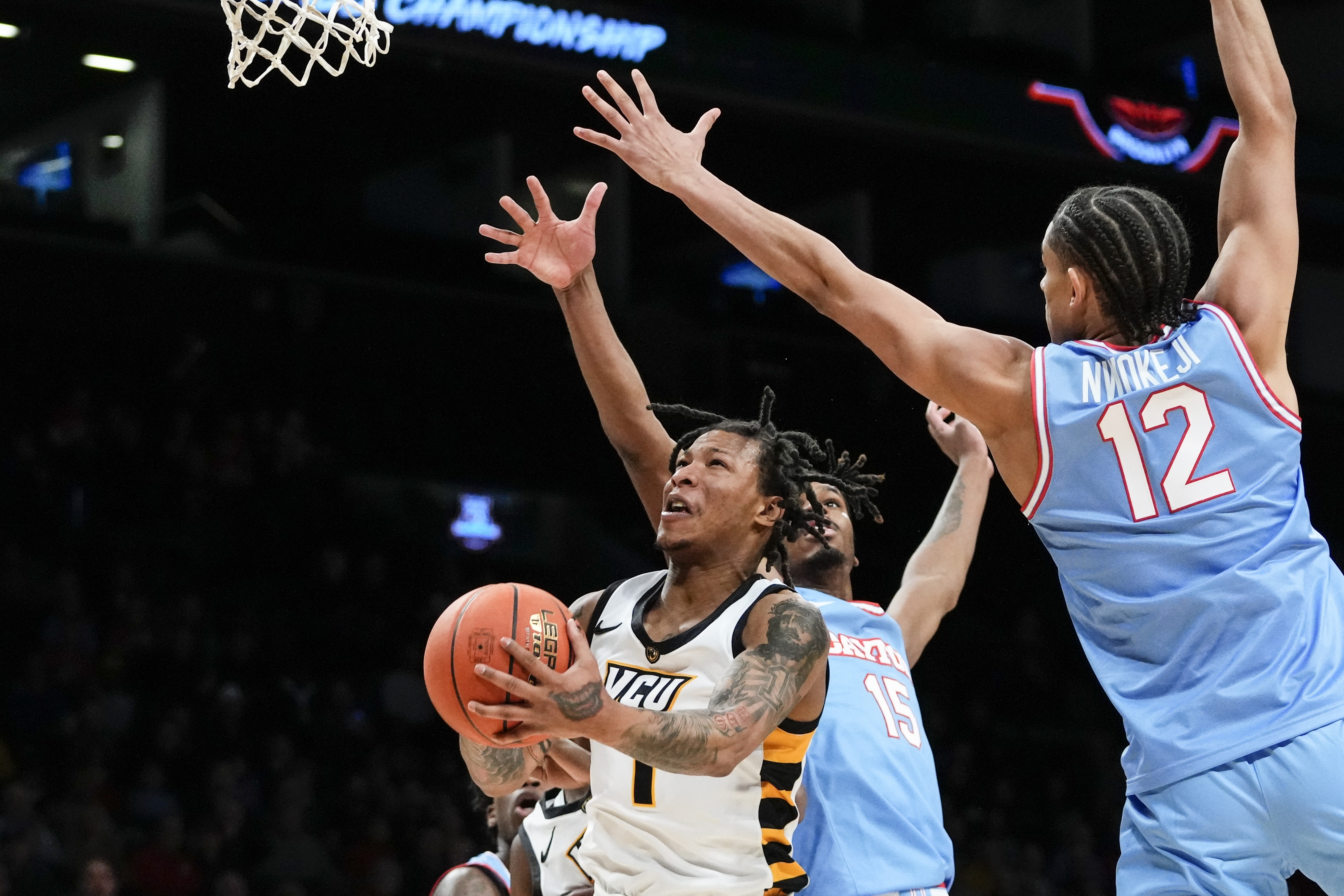 Virginia Commonwealth's Adrian Baldwin Jr. (1) drives past Dayton's Zimi Nwokeji (12) and DaRon Holmes II (15) during the first half of an NCAA college basketball game in the championship of the Atlantic 10 Conference Tournament, Sunday, March 12, 2023, in New York.