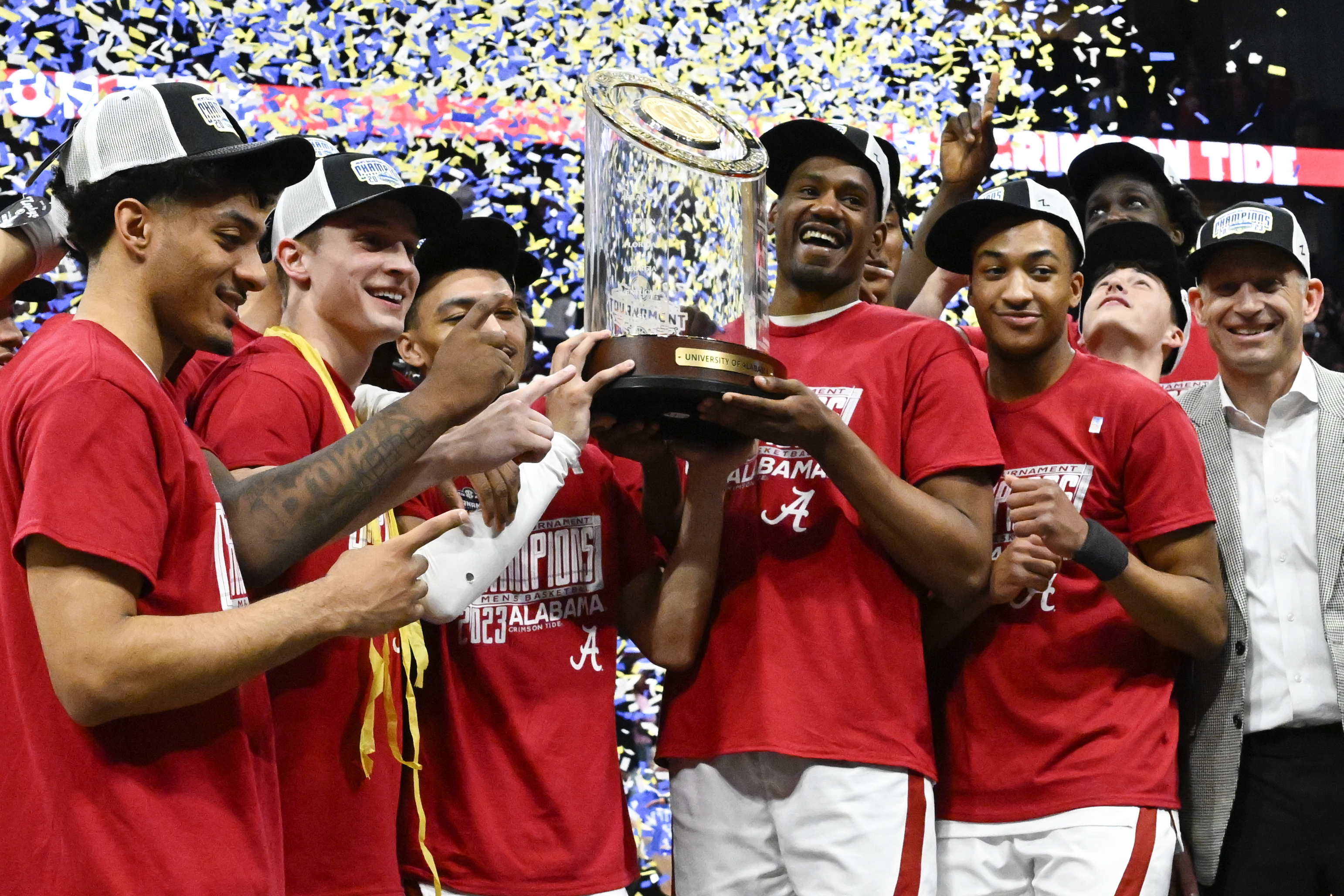 Alabama players pose with the trophy after an NCAA college basketball game against Texas A&M in the finals of the Southeastern Conference Tournament, Sunday, March 12, 2023, in Nashville, Tenn. Alabama won 82-63. 