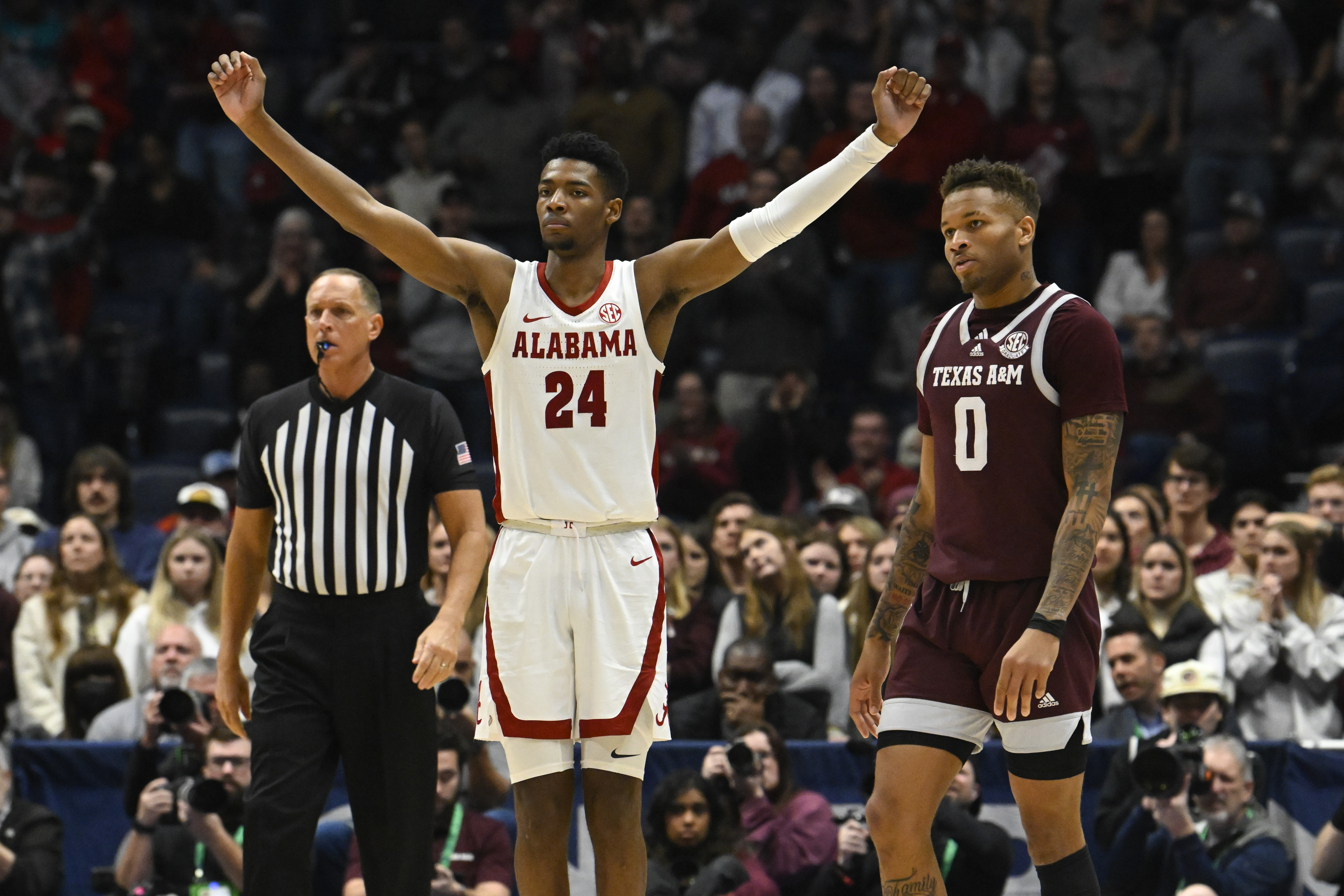 Alabama forward Brandon Miller (24) reacts as Texas A&M guard Dexter Dennis (0) looks on in the final minutes of an NCAA college basketball game in the finals of the Southeastern Conference Tournament, Sunday, March 12, 2023, in Nashville, Tenn. 