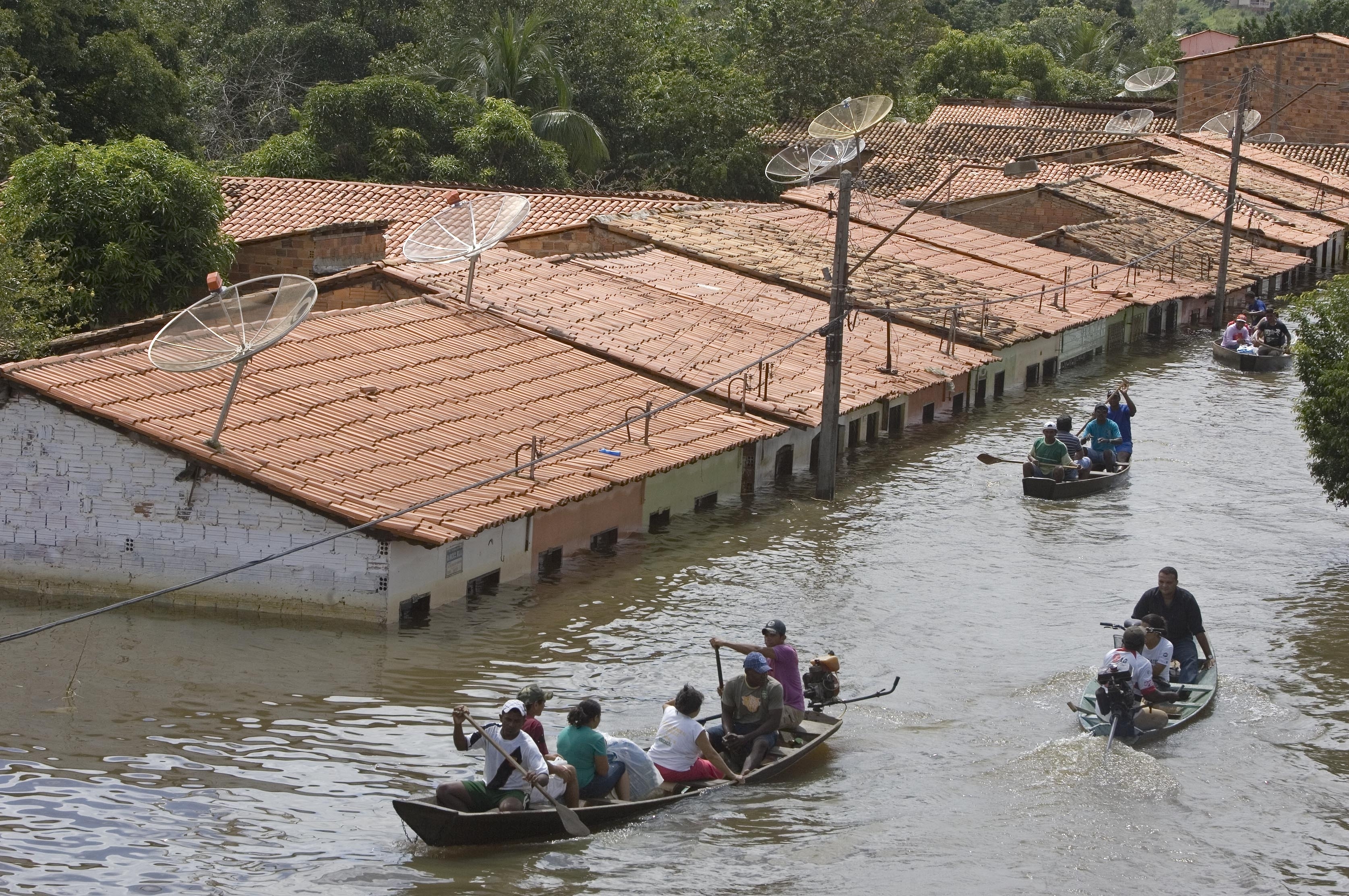 People travel by boat in a flooded street in Trizidela do Vale, Brazil, May 9, 2009. The intensity of extreme drought and rainfall has “sharply” increased over the past 20 years, according to a study published Monday. 