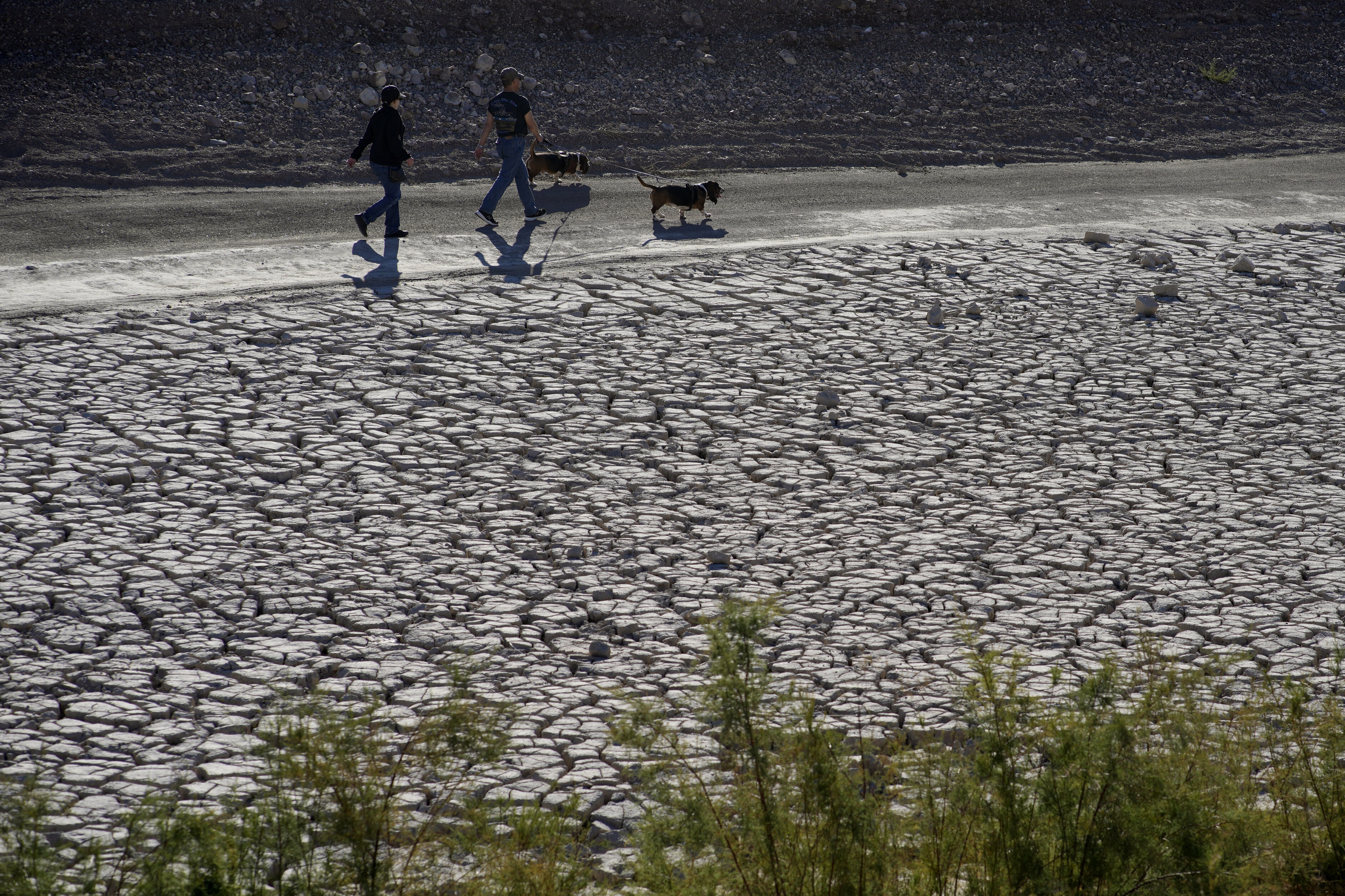 People walk by cracked earth in an area once under the water of Lake Mead at the Lake Mead National Recreation Area, Jan. 27 near Boulder City, Nev. The intensity of extreme drought and rainfall has “sharply” increased over the past 20 years, according to a study published Monday.