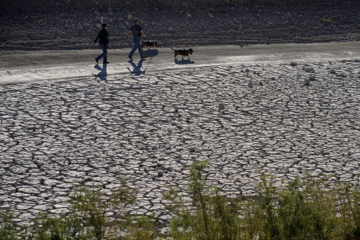 People walk by cracked earth in an area once under the water of Lake Mead at the Lake Mead National Recreation Area, Jan. 27 near Boulder City, Nev. The intensity of extreme drought and rainfall has “sharply” increased over the past 20 years, according to a study published Monday.