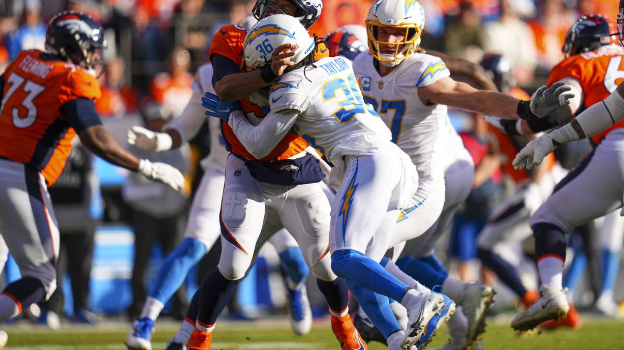 FILE - Denver Broncos quarterback Russell Wilson (3) is hit by Los Angeles Chargers cornerback Ja'Sir Taylor (36) during an NFL football game Jan. 8, 2023, in Denver. Taylor was penalized for roughing-the-passer on the play. The NFL’s competition committee will consider making roughing-the-passer penalties and personal-foul penalties subject to video review.