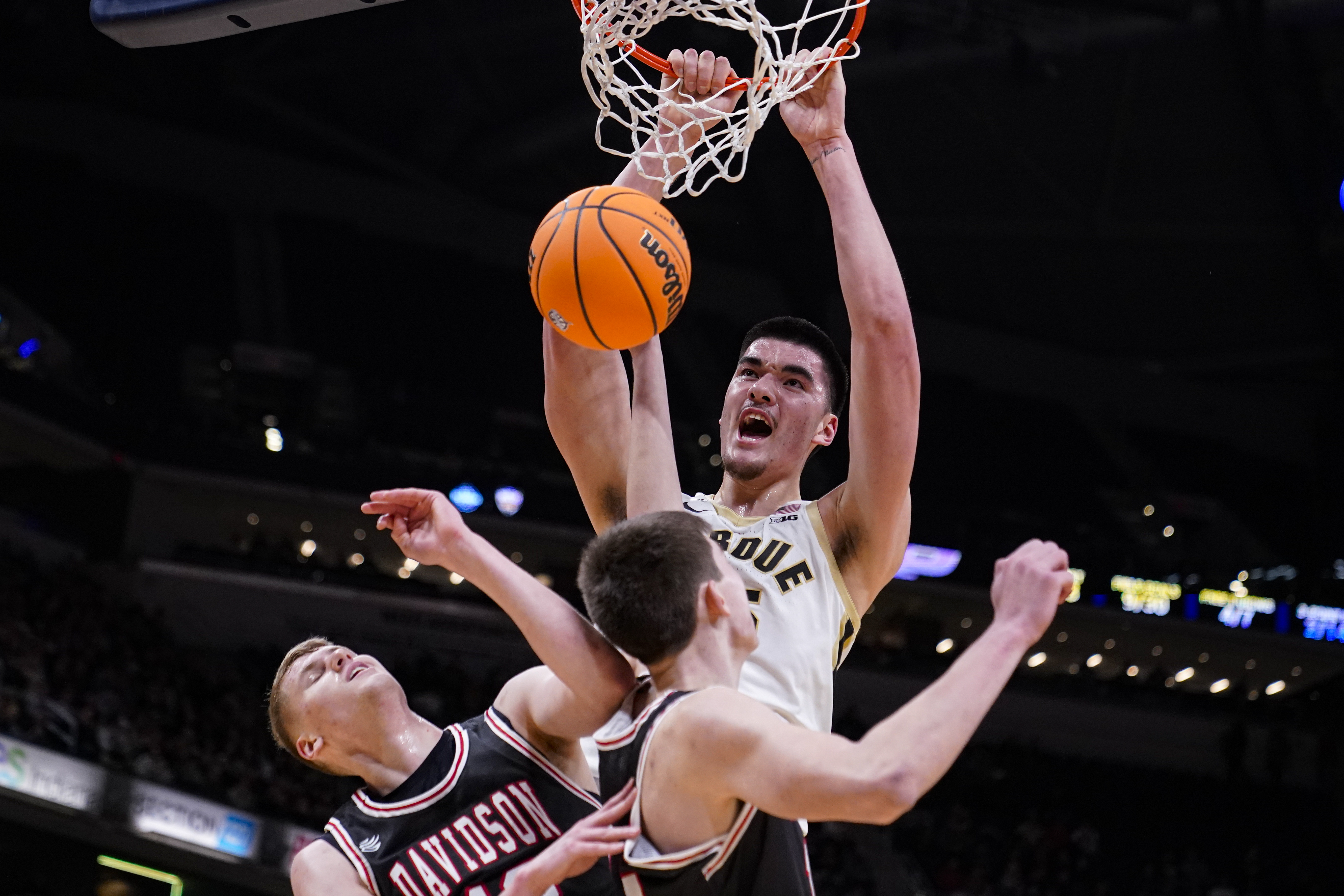 FILE - Purdue center Zach Edey (15) gets a dunk over Davidson forward David Skogman, left, and forward Sean Logan in the first half of an NCAA college basketball game in Indianapolis, Saturday, Dec. 17, 2022. Purdue’s Zach Edey and Indiana’s Trayce Jackson-Davis have given the Big Ten Conference a third straight year with multiple first-team Associated Press All-America picks. Edey was the lone unanimous pick in results released Tuesday, March 14, 2023.