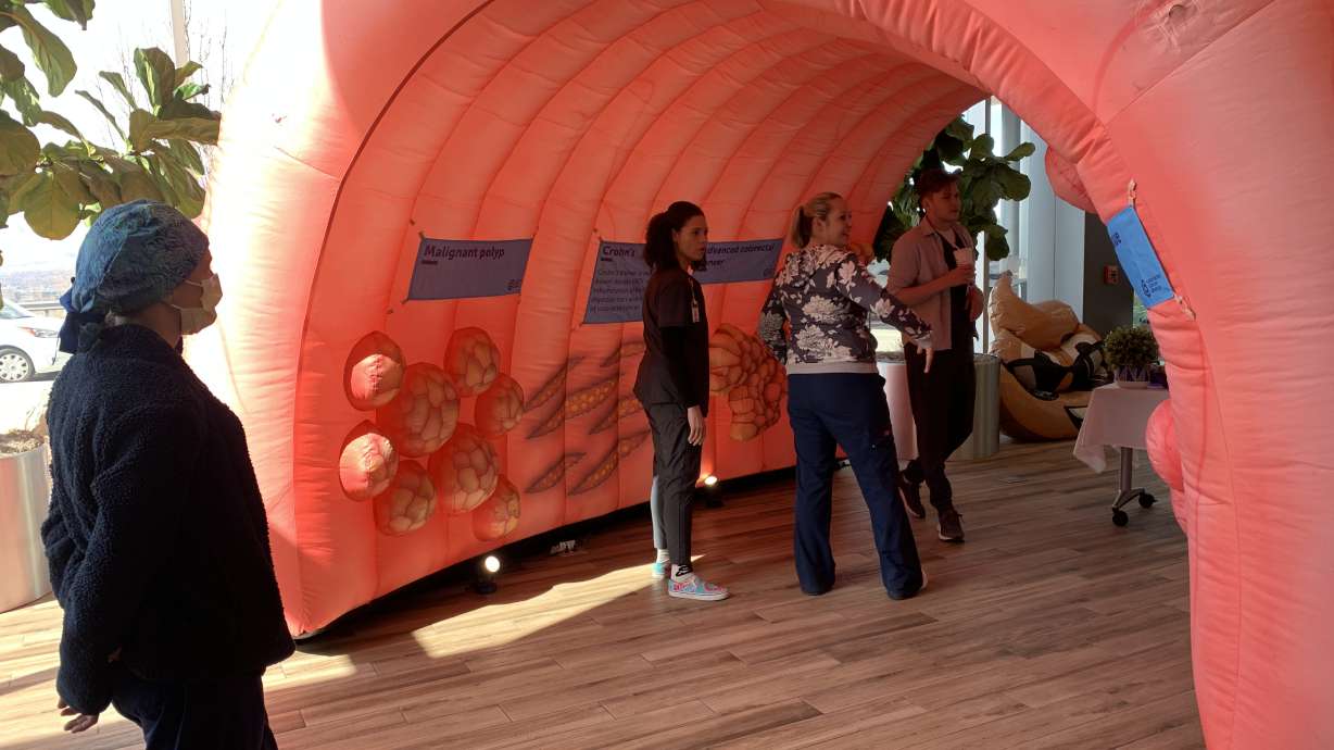 Intermountain Health employees walk through an inflatable colon display at Intermountain Health's Alta View Hospital on Monday.