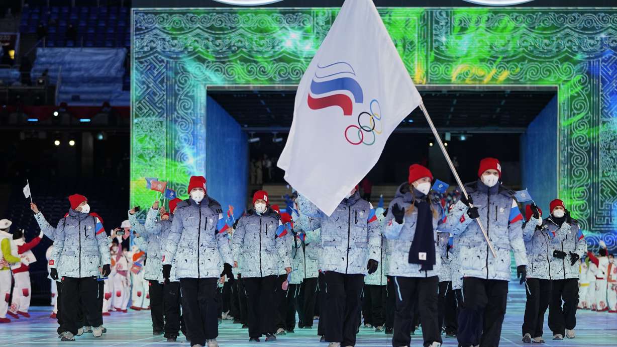 Russian Olympic Committee members carry a flag at the 2022 Winter Olympics, on Feb. 4, 2022, in Beijing. The British government is pushing Olympic sponsors to put pressure on the International Olympic Committee over Russians and Belarusians competing as neutral athletes in the 2024 Summer Games in Paris.