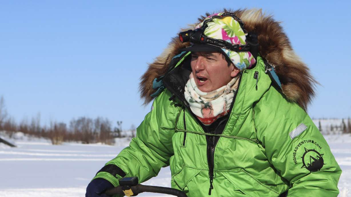 FILE - Ryan Redington heads out after stopping briefly at the Iditarod checkpoint of the Iditarod Trail Sled Dog Race on March 11, 2021. The winner of the Iditarod Trail Sled Dog Race pockets only about $50,000, but the real prize is a bronze statue of race co-founder Joe Redington Sr. embracing a sled dog under the iconic burled arch finish line. Ever since the first grueling Iditarod race across the Alaska wilderness, mushers with the last name Redington have lined up 71 times to win that trophy.