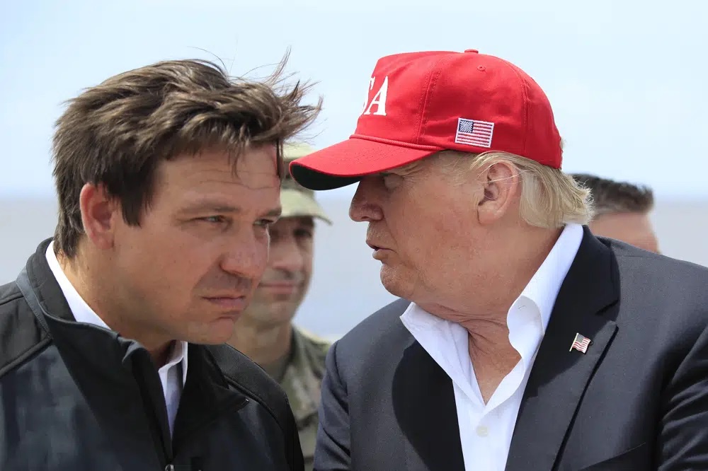 President Donald Trump talks to Florida Gov. Ron DeSantis, left, at Canal Point, Florida, March 29, 2019. Allies of Trump have filed a complaint with the Florida Commission on Ethics against the state’s governor, Ron DeSantis.