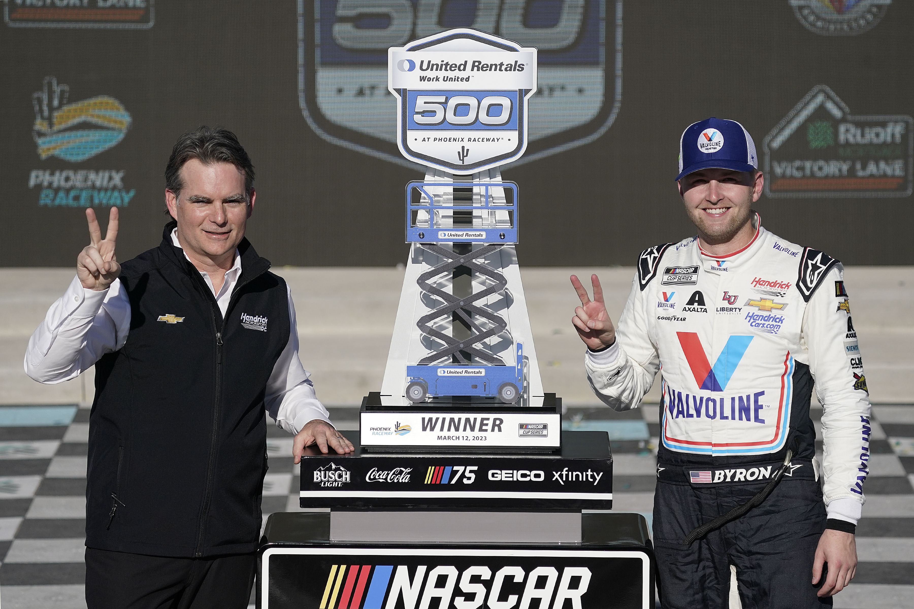 NASCAR legend Jeff Gordon, left, and William Byron, pose with Byron's trophy after winning the NASCAR Cup Series auto race at Phoenix Raceway, Sunday, March 12, 2023, in Avondale, Ariz. 