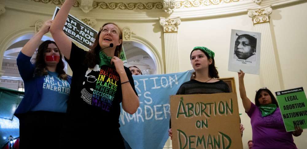 Sarah Bentley leads songs at an International Women's Day Sit-In for Abortion Rights at the Texas state Capitol Rotunda, Wednesday in Austin, Texas. A federal judge in Texas told lawyers not to publicize upcoming arguments in the lawsuit.