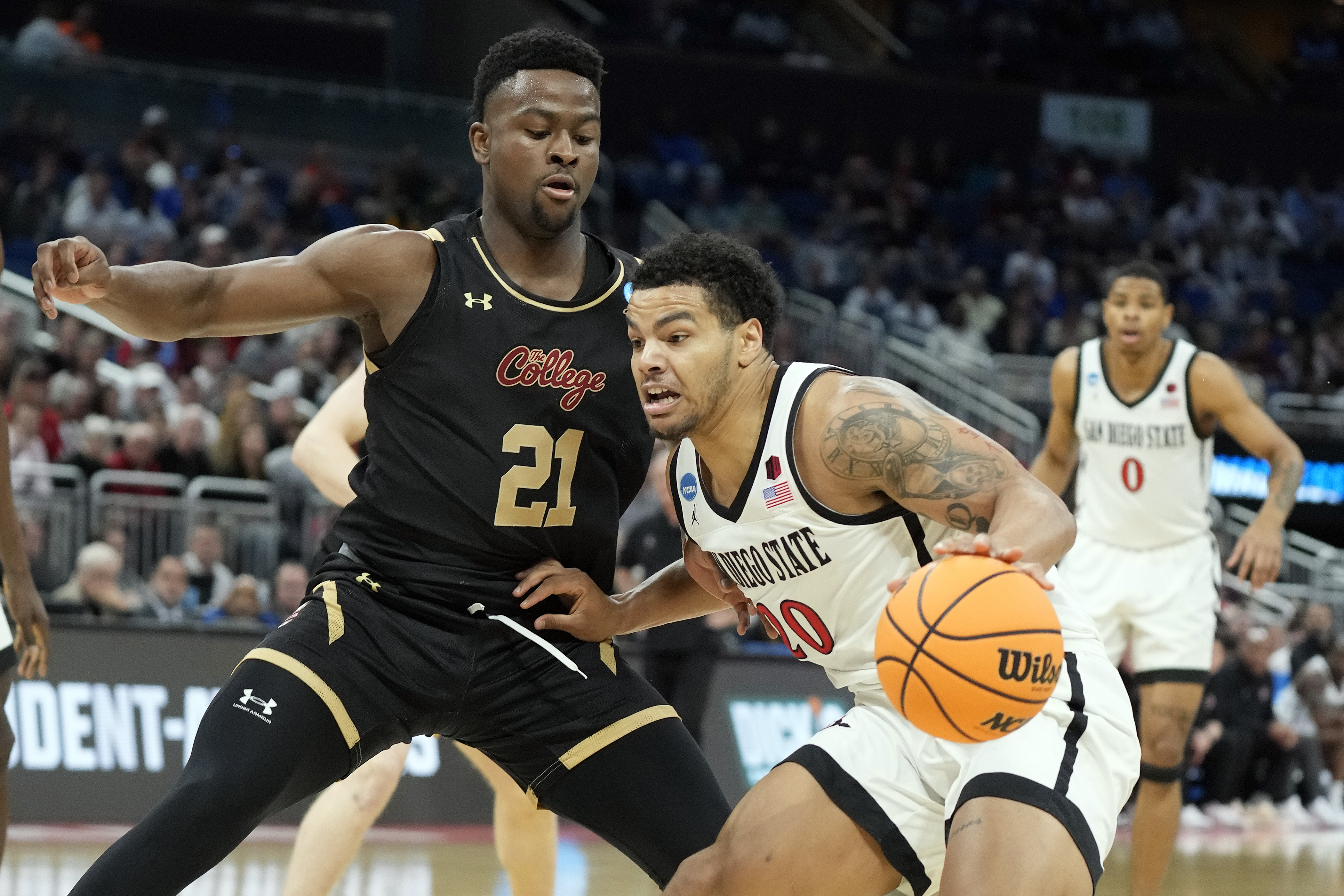 San Diego State guard Matt Bradley (20) gets around Charleston guard Jaylon Scott (21) during the first half of an first-round college basketball game in the NCAA Tournament Thursday, March 16, 2023, in Orlando, Fla. 