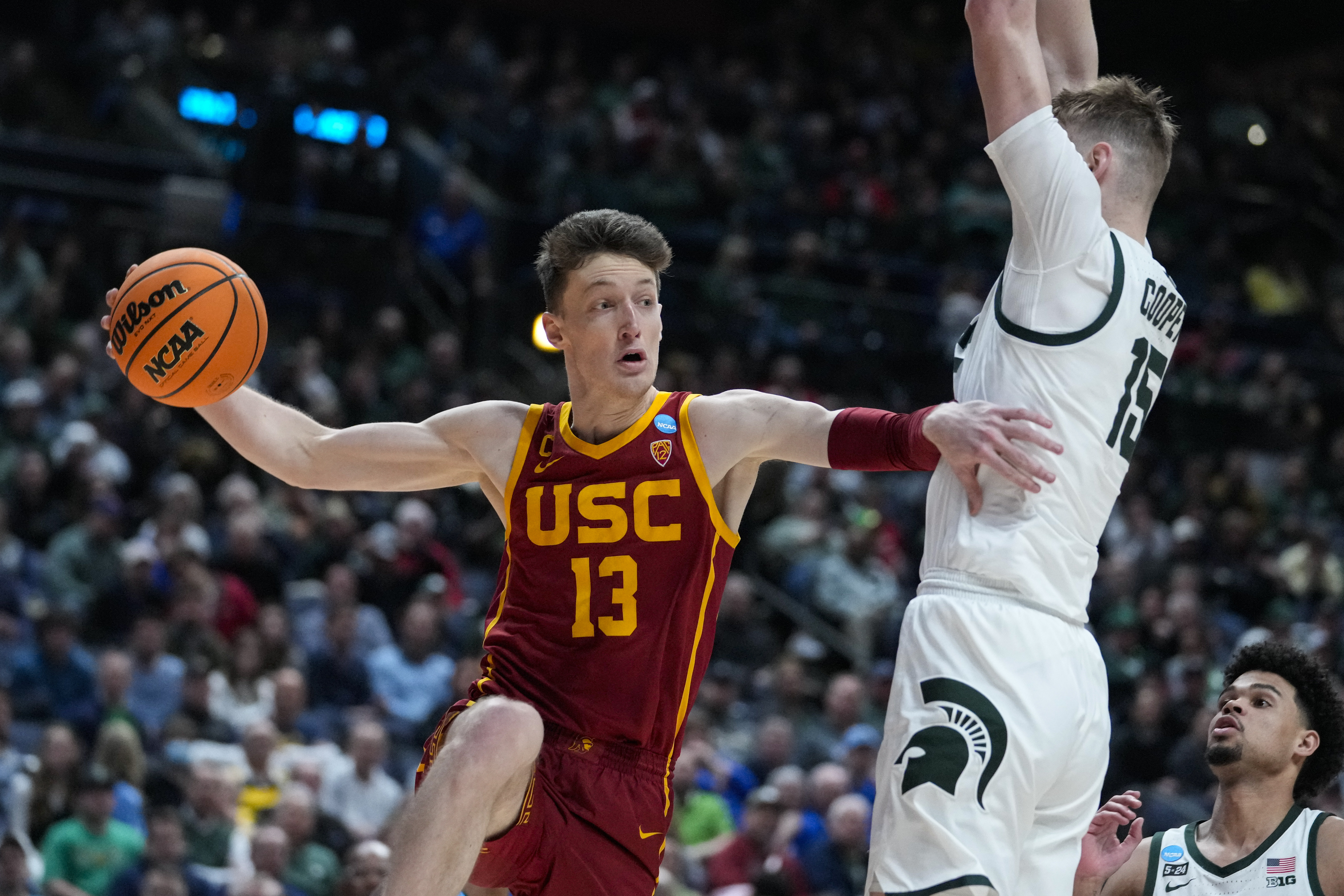 Southern California guard Drew Peterson (13) makes a pass around Michigan State center Carson Cooper (15) in the second half of a first-round college basketball game in the men's NCAA Tournament in Columbus, Ohio, Friday, March 17, 2023. 