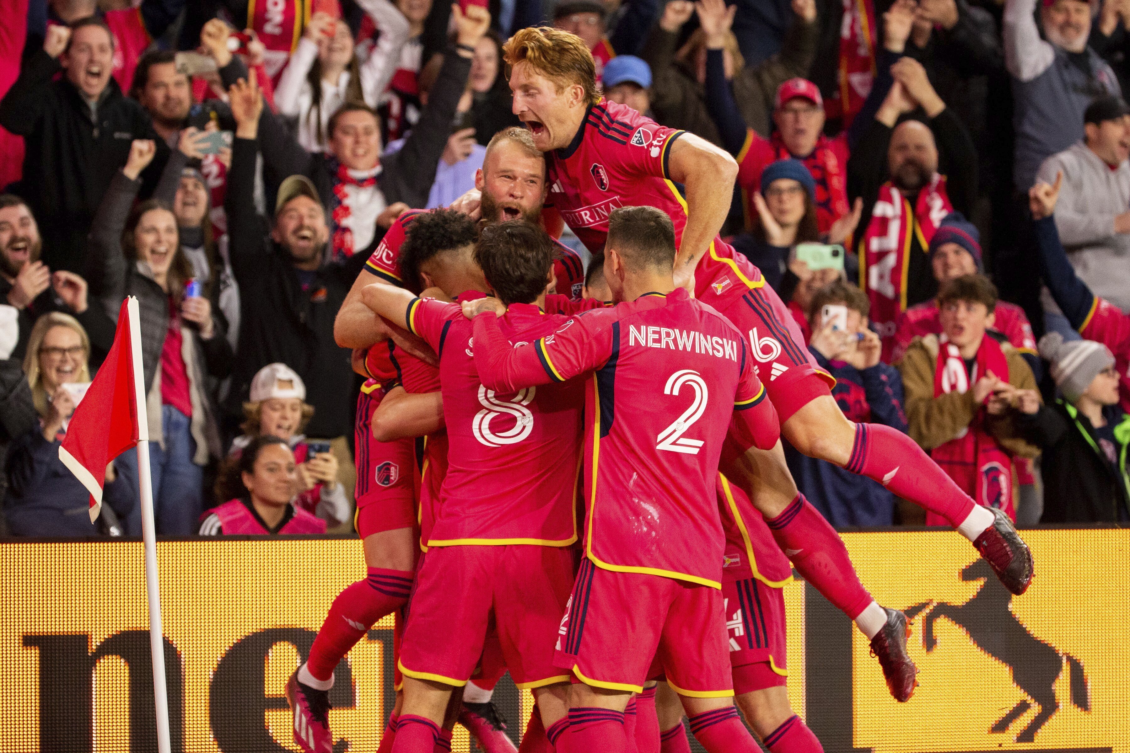 St. Louis City SC players celebrate after midfielder Eduard Lowen scored off a penalty kick in their first home MLS soccer match, against Charlotte FC, Saturday, March 4, 2023, in St. Louis.