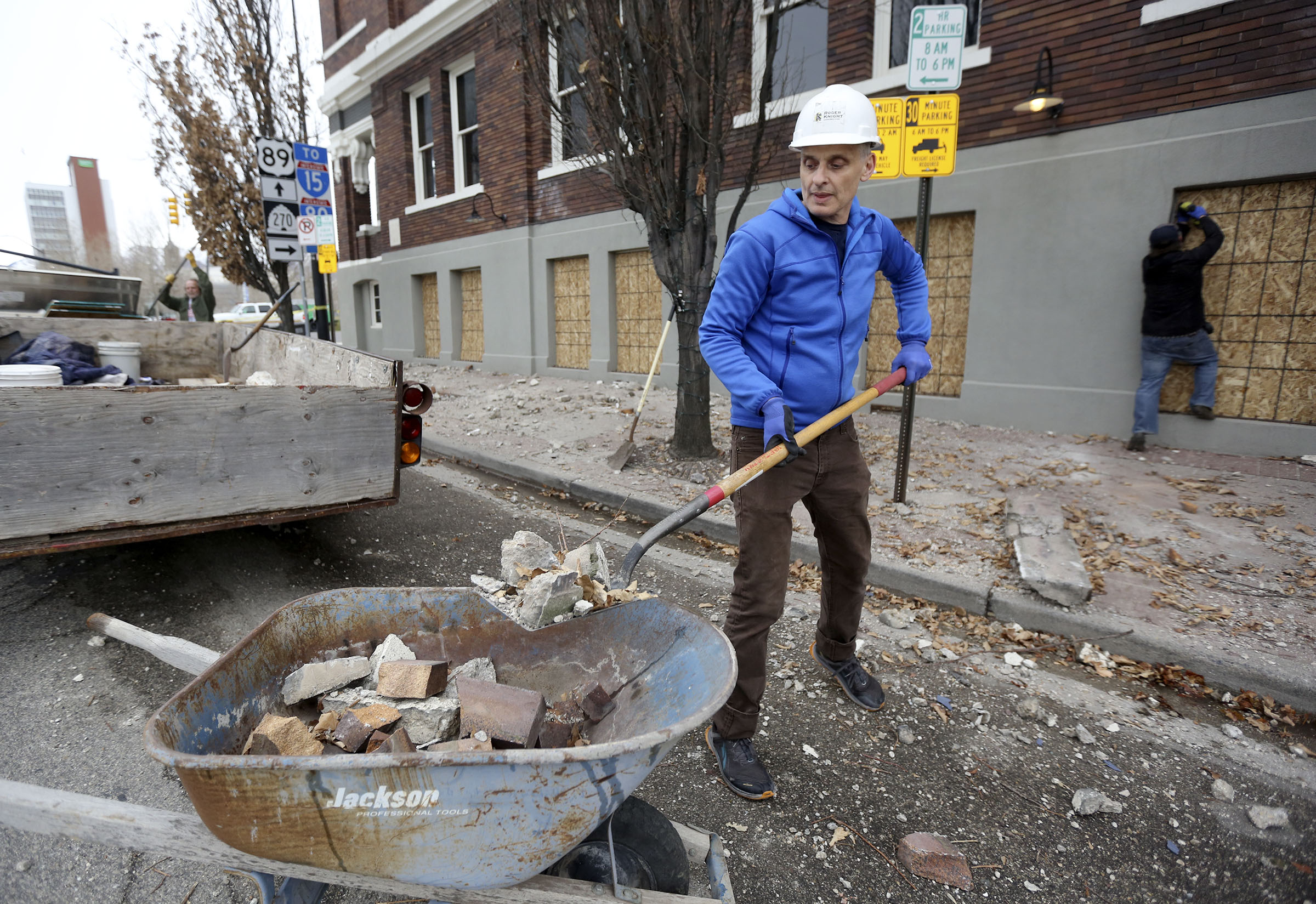 Paul Foster, a waiter at Caffe Moilse, shovels debris that fell from the building in Salt Lake City after a 5.7 magnitude earthquake centered in Magna hit early March 18, 2020.