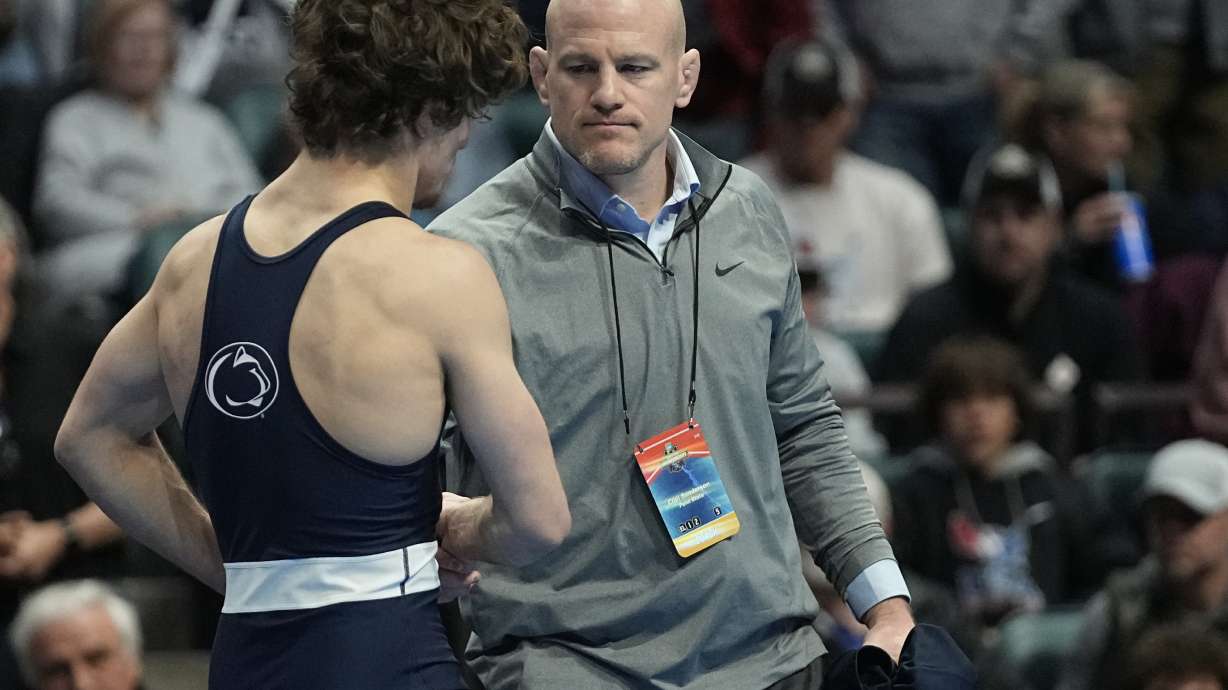 Penn State head coach Cael Sanderson, right, consoles Levi Haines after Haines was defeated by North Carolina's Austin O'Connor in the 157 lb. championship match the NCAA Wrestling Championships, Saturday, March 18, 2023, in Tulsa, Okla.