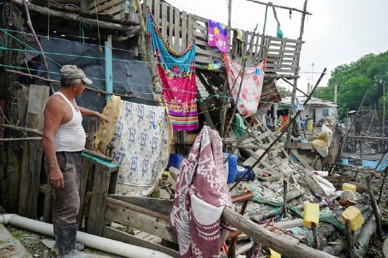 A man points at a damaged house following an earthquake in Isla Puna, Ecuador, Sunday.