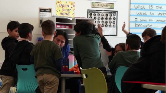 Students gather around Nate Manuel for a daily lesson in this undated photo.