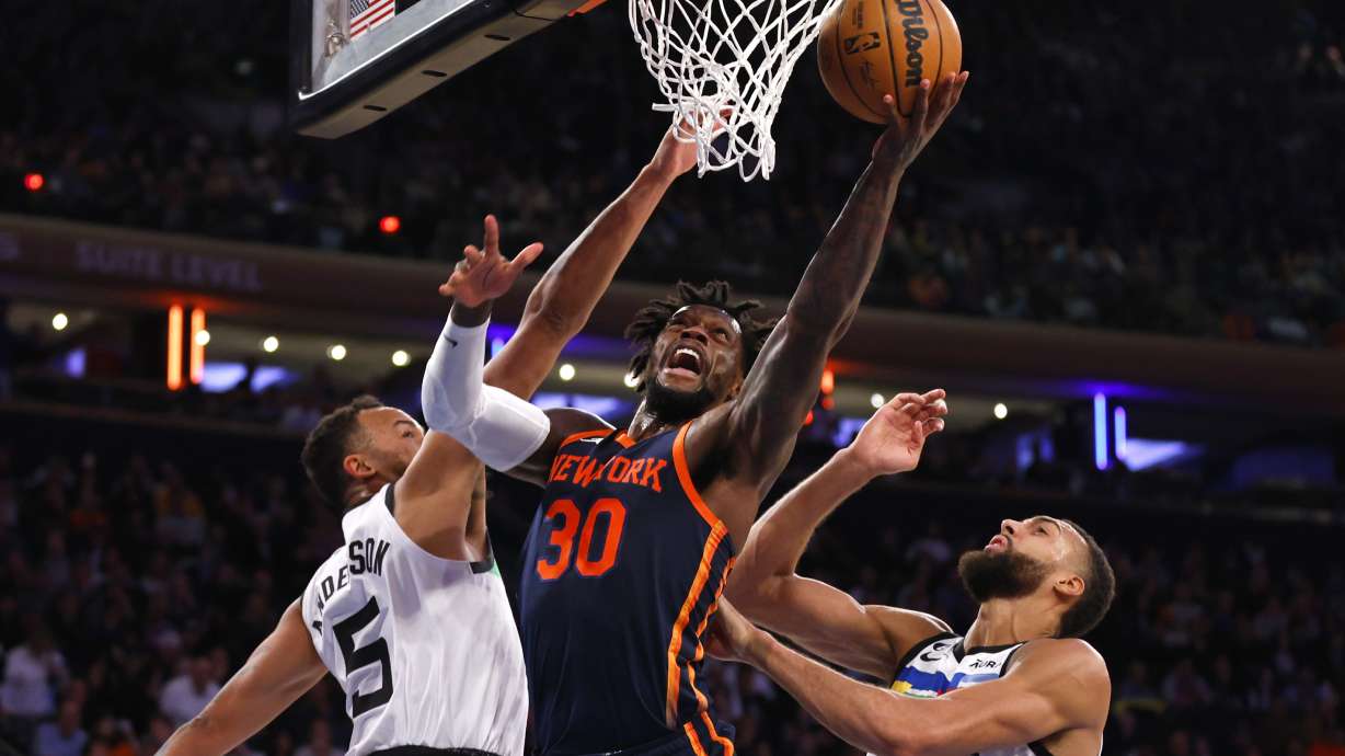 New York Knicks forward Julius Randle (30) drives to the basket against Minnesota Timberwolves forward Kyle Anderson (5) and center Rudy Gobert (27) during the second half of an NBA basketball game, Monday, March 20, 2023, in New York.