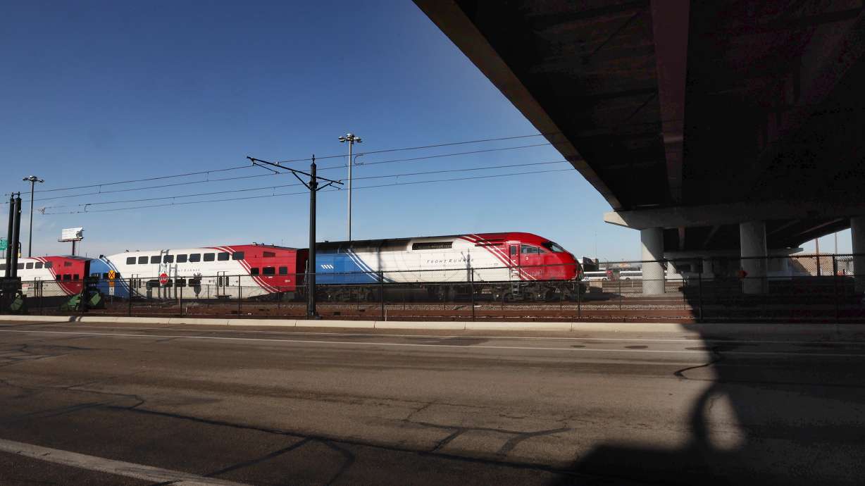 A FrontRunner train moves through the area where a bicyclist was killed earlier in the morning after being hit in Salt Lake City on Tuesday.