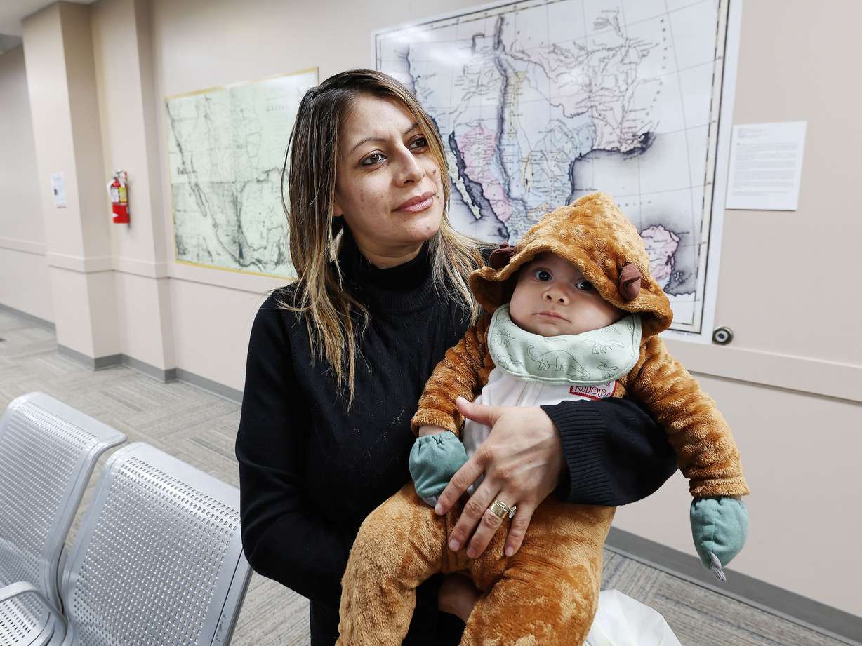Marie Jimenez holds her daughter Noe while applying for a passport at the Mexican Consulate in Salt Lake City on Wednesday, Dec. 21, 2022.