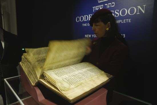 A member of staff shows the Hebrew Bible "Codex Sassoon," that dates back more than 1,000 years, on display during a media preview of Sotheby's auction, in London, Feb. 22. The piece has an estimated price of $30-50 million and will go on auction on May in New York.