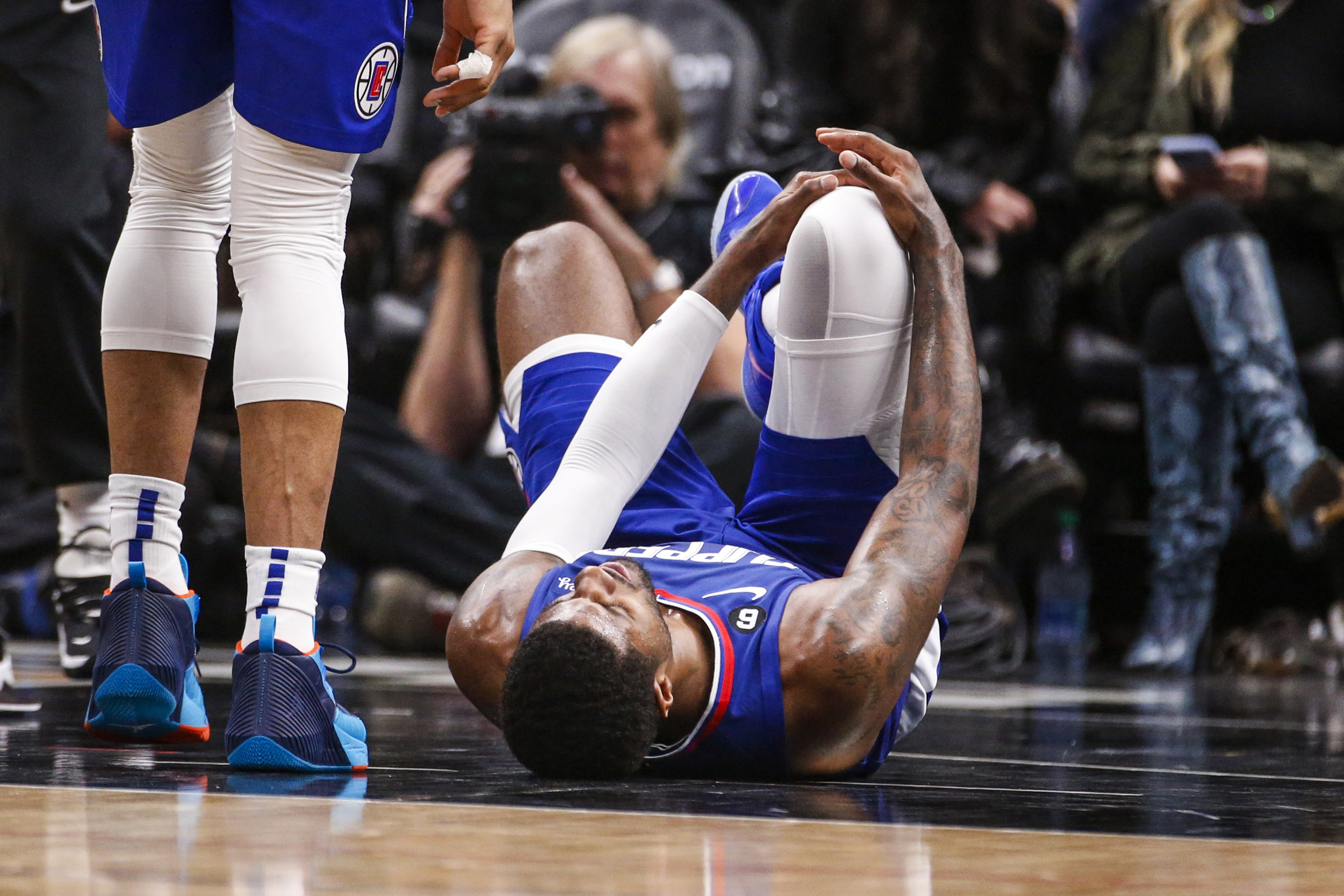 Los Angeles Clippers forward Paul George, right, lies on the court after an injury during the second half of an the team's NBA basketball game against the Oklahoma City Thunder on Tuesday, March 21, 2023, in Los Angeles.