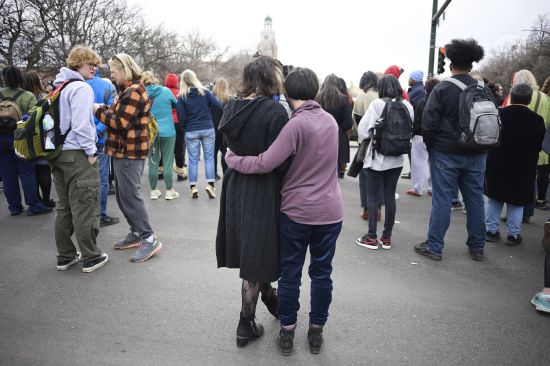 Isabella DeJoseph, 15, center left, is embraced by her mother Alana as they leave East High School after a school shooting, Wednesday in Denver. Two school administrators were shot at the high school Wednesday morning after a handgun was found on a student subjected to daily searches, authorities said.