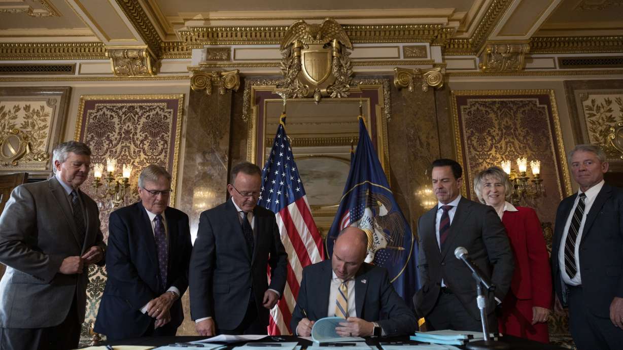 Utah Gov. Spencer Cox signs a record $400 million tax cut into law in the Gold Room at the Capitol on Wednesday.