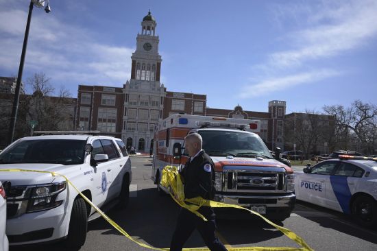Emergency personnel remove police tape outside East High School after a school shooting, Wednesday in Denver.