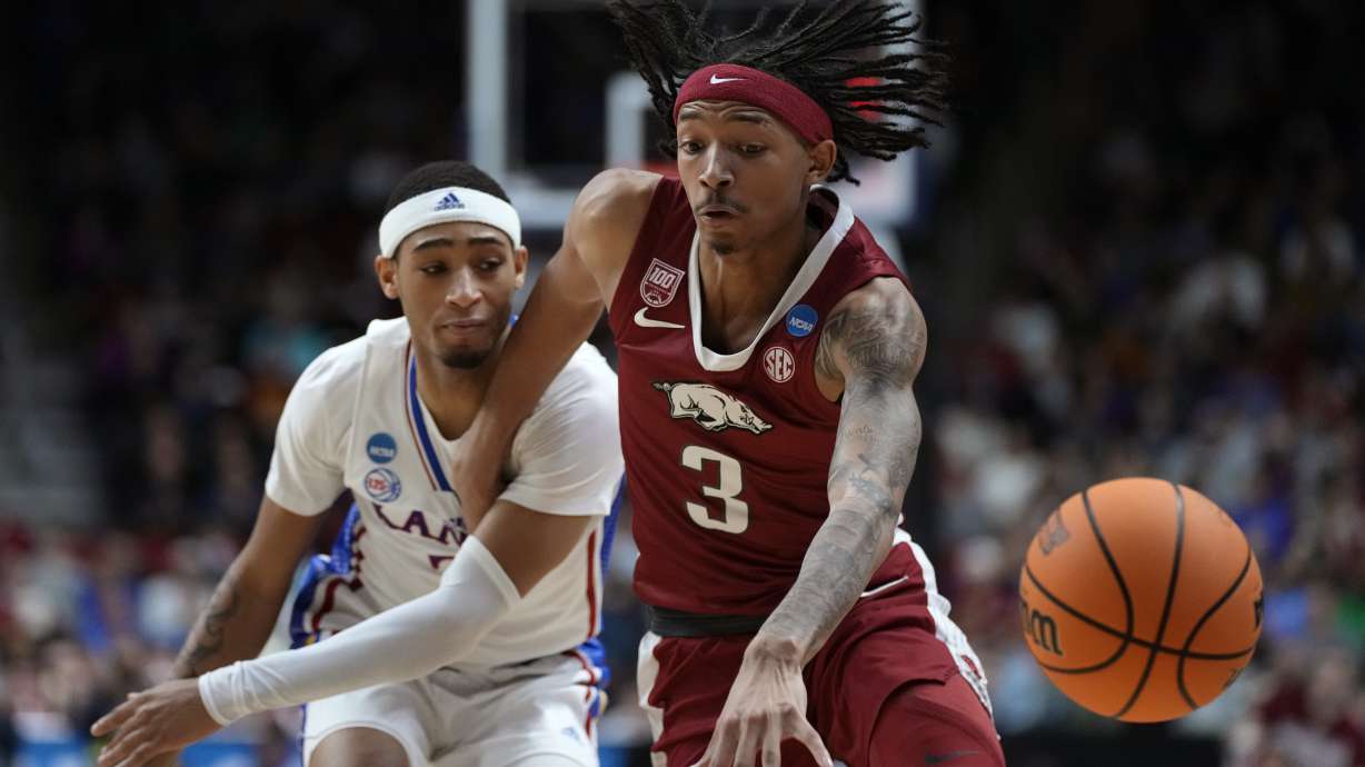 Arkansas guard Nick Smith Jr. loses control of the ball as he drives past Kansas guard Dajuan Harris Jr., left, in the first half of a second-round college basketball game in the NCAA Tournament, Saturday, March 18, 2023, in Des Moines, Iowa.