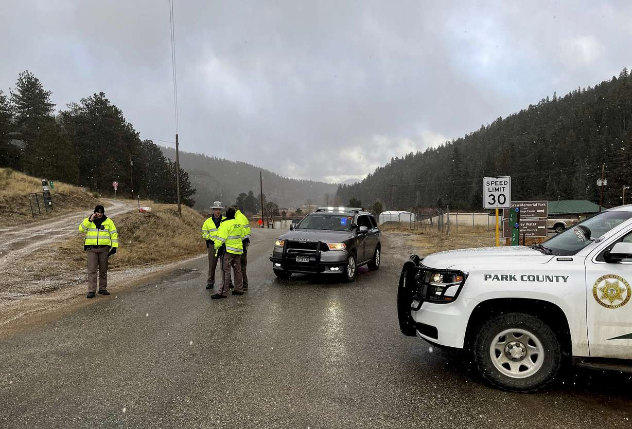 Sheriff deputies block a road in the town of Bailey, Colo., where authorities found an abandoned car that belonged to the suspect in a shooting of two administrators at a Denver high school Wednesday.