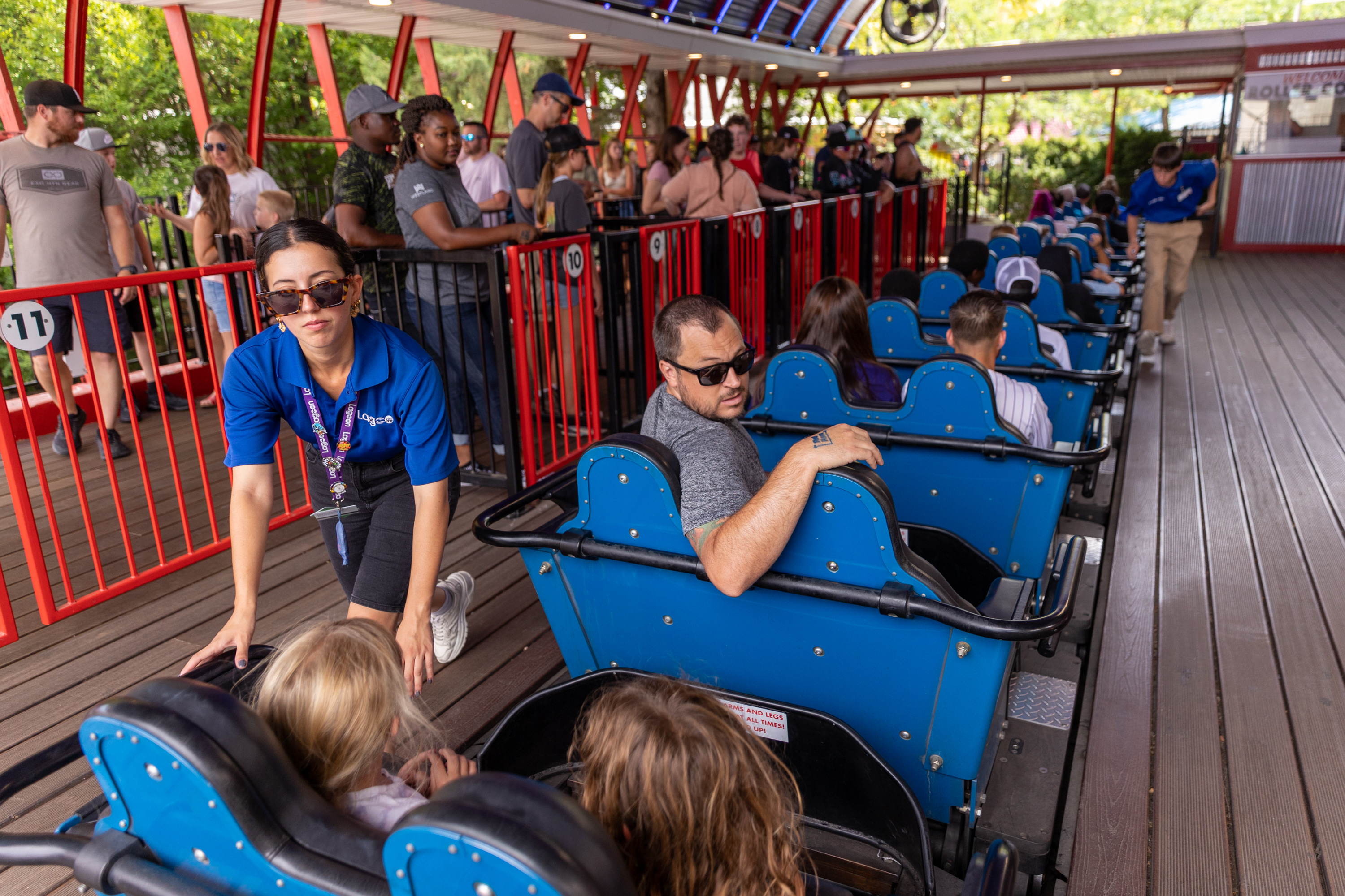 Yelitza R. checks safety restraints on a roller coaster at Lagoon in Farmington on Aug. 5, 2022. Lagoon's opening day for 2023 was postponed to April 1 because of inclement weather.