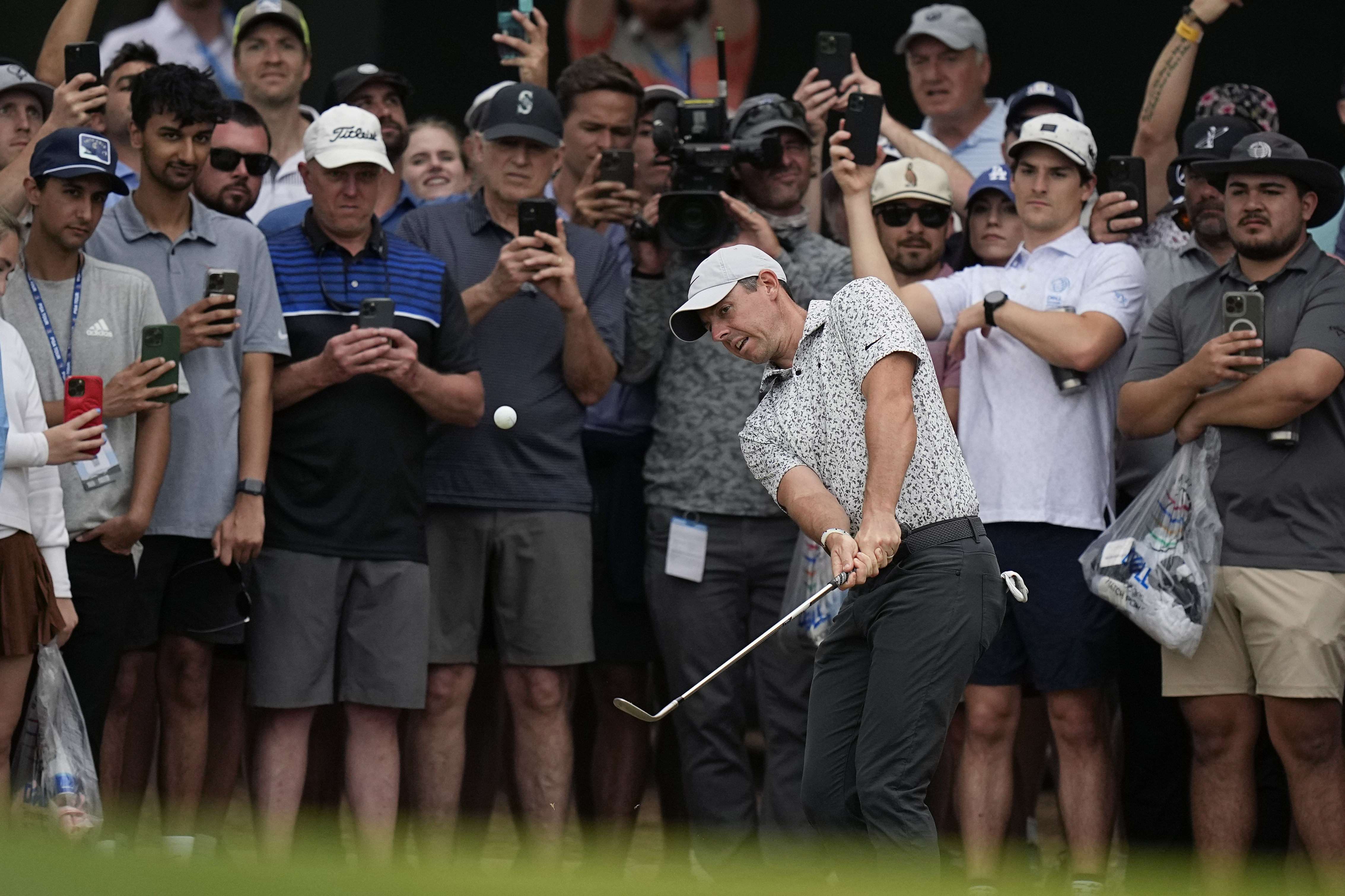 Rory McIlroy, of Northern Ireland, center, chips to the green on the sixth hole during the second round of the Dell Technologies Match Play Championship golf tournament in Austin, Texas, Thursday, March 23, 2023.
