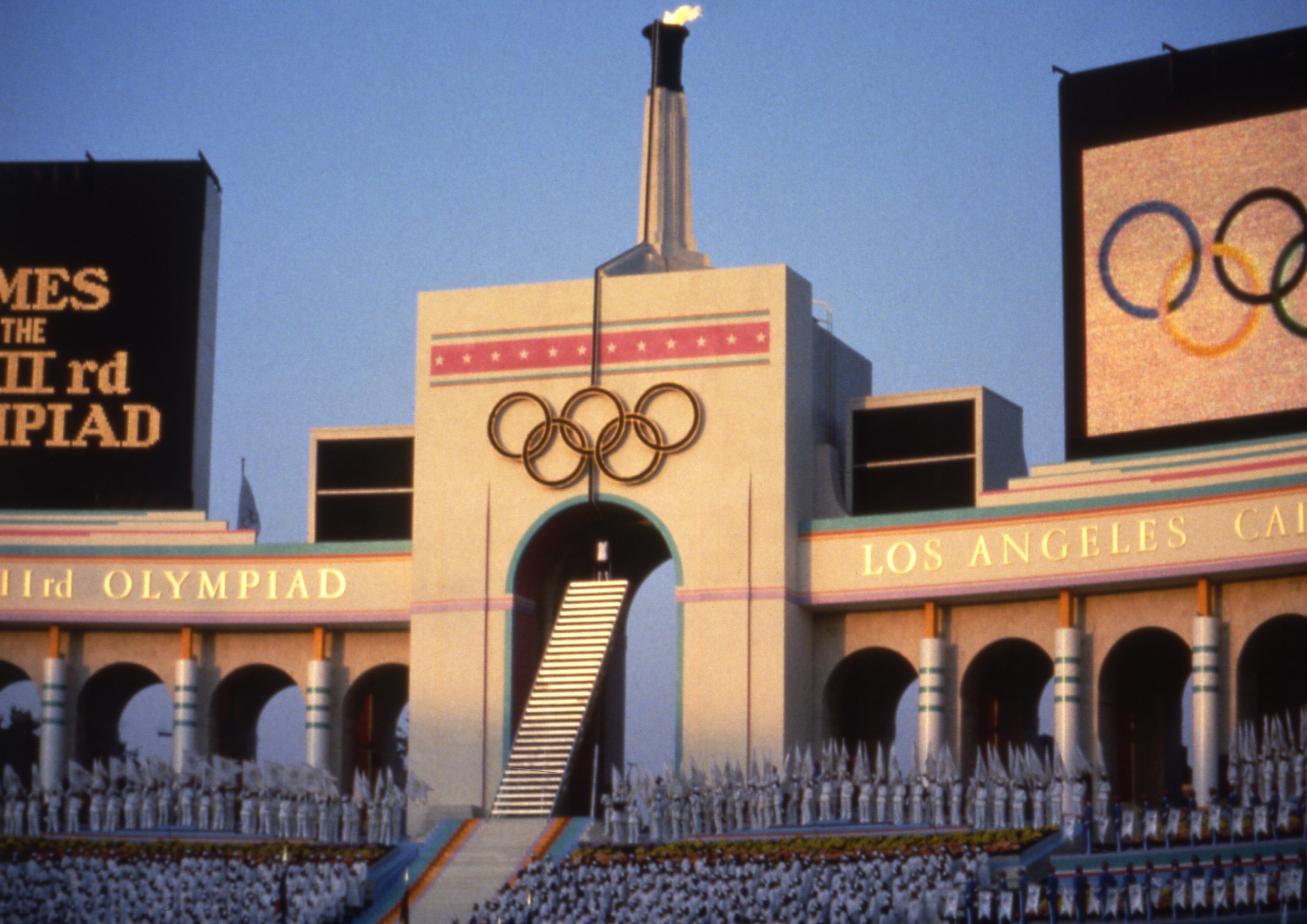 The Olympic flame is flanked by scoreboards signifying the formal opening of the XXIII Olympics in Los Angeles Memorial Coliseum, July 28, 1984. Los Angeles residents say they are excited to host another Olympics, according to recent poll.