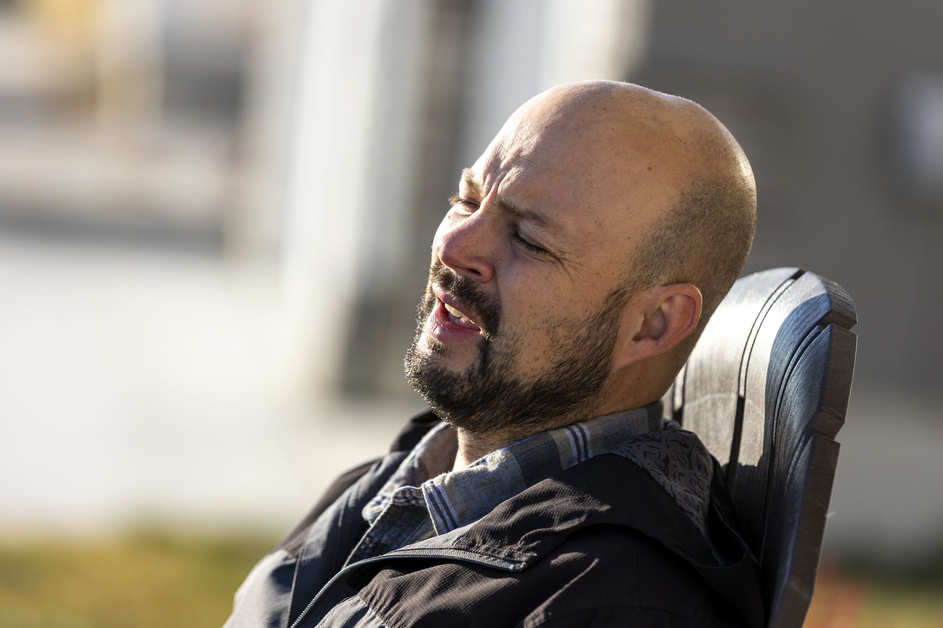 Blake Bockholt struggles to breathe as sits outside to watch his son mow the lawn at his home in Syracuse on Nov. 20, 2022. Bockholt struggles with symptoms from long COVID-19.