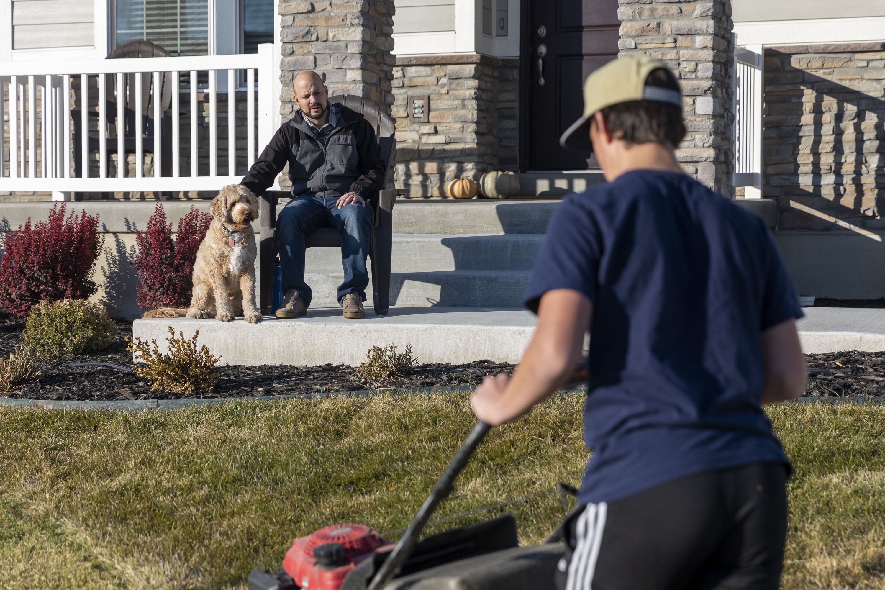 Blake Bockholt sits as he watches his son, Josh, 13, mow the lawn at their home in Syracuse on Nov. 20, 2022. Blake struggles with symptoms from long COVID-19.