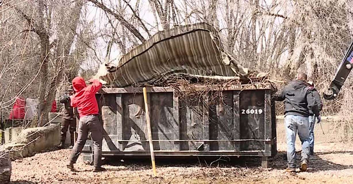 Crews clearing the water and banks of Little Cottonwood Creek put debris in a Dumpster Thursday. They fill multiple Dumpsters each day during spring cleanup.
