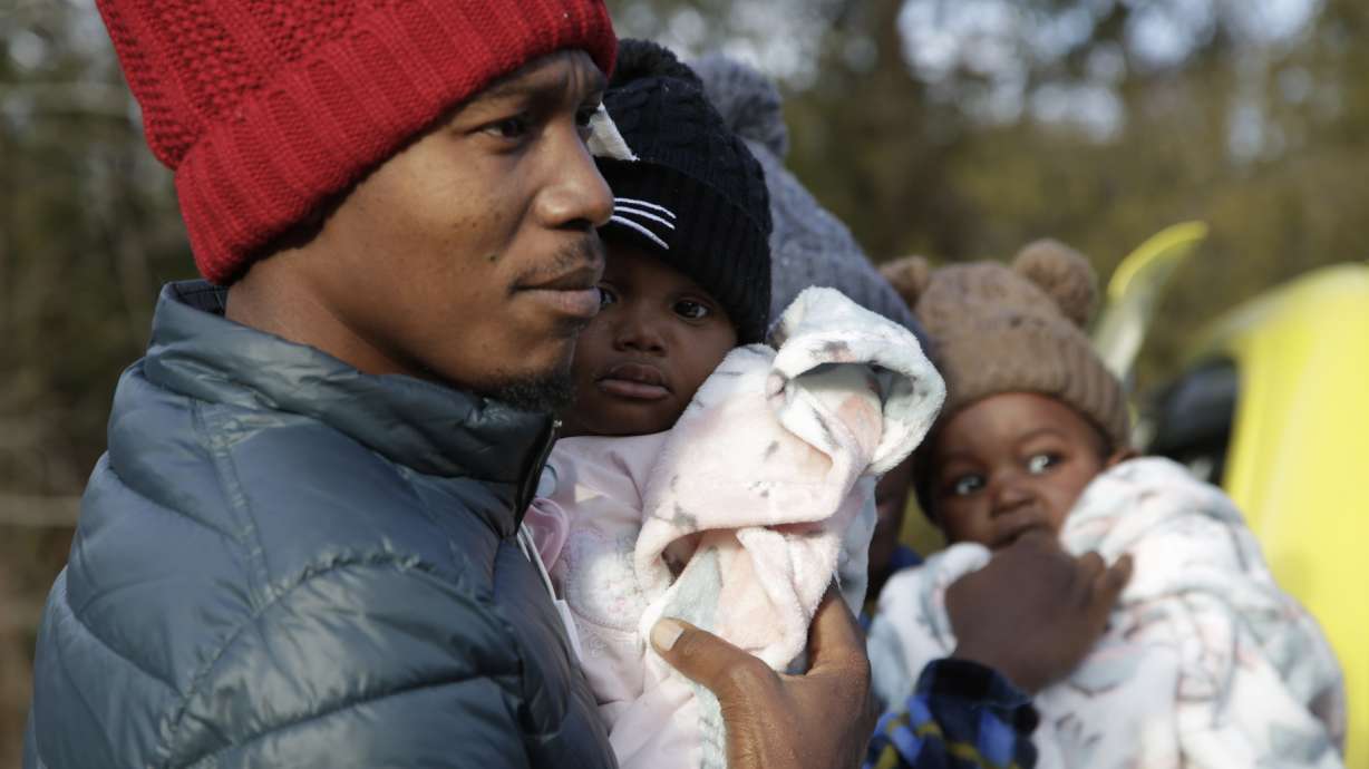 Migrant Gerson Solay, 28, carries his daughter at the Roxham Road border crossing north of Champlain, N.Y., on Friday. An agreement closes a loophole that allowed migrants who enter Canada away from border posts to stay there while awaiting an asylum decision.