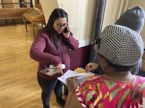 Karla Elizalde helps a Haitian immigrant couple in St. Johnsbury, Vt., on Thuesday. The couple and their three children, aged 17, 15, and 9, were dropped off in arrived in St. Johnsbury on Thursday by the U.S. Border Patrol.
