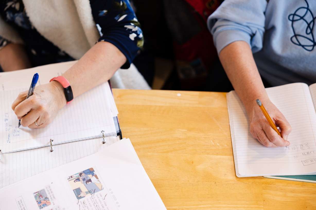 Jodee Steffensen, left, and Susan Clark, write in their notebooks during a Korean language lesson at Yummy's Korean BBQ restaurant in West Valley City on March 25.