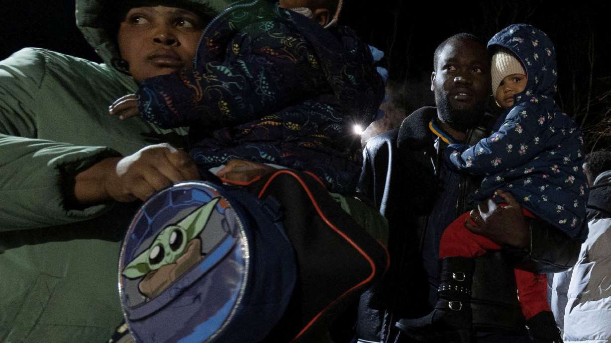 Migrants cross after midnight into Canada at Roxham Road, an unofficial crossing point from New York state to Quebec for asylum seekers, in Champlain, New York.