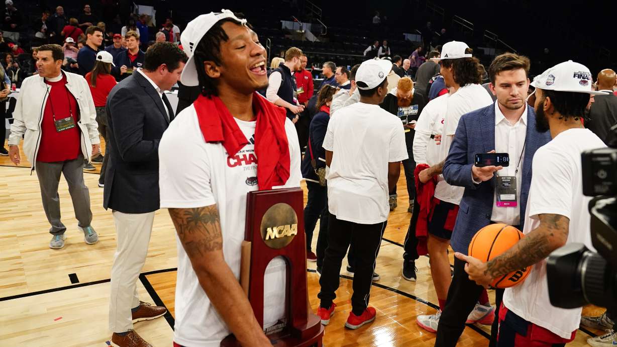 Florida Atlantic's Isaiah Gaines (5) holds the trophy as Florida Atlantic players celebrate after defeating Kansas State in an Elite 8 college basketball game in the NCAA Tournament's East Region final, Saturday, March 25, 2023, in New York.